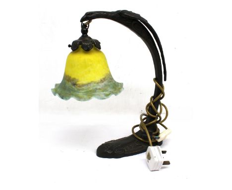 An Art Deco style patinated metal Falcon designed lamp with iridescent glass shade.
