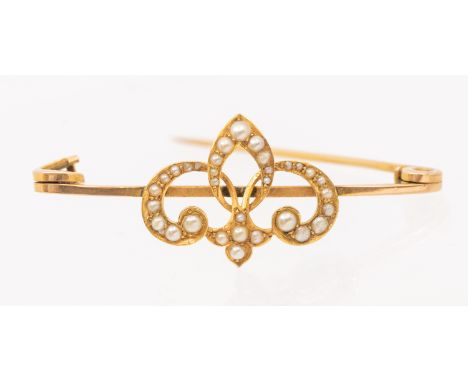 A vintage seed pearl and 9ct gold brooch, scrolled pearl set motif to a bar, length approx 50mm, total gross weight approx 4.