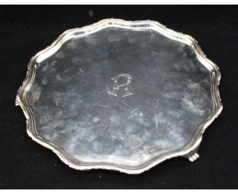 A George VI silver salver, of curved circular shape, with part beaded rim and on three cast scrolled feet, engraved initial R