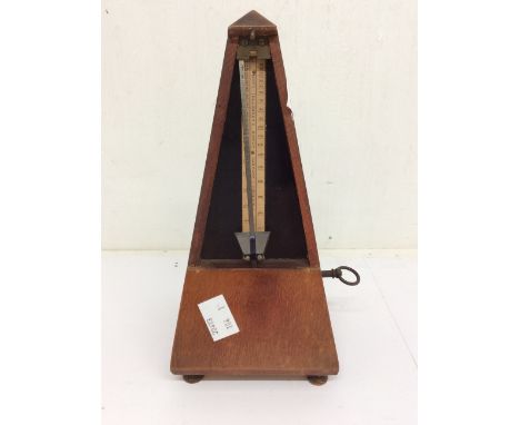 A wooden cased Maezel metronome, in working order.