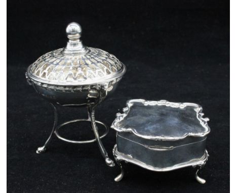 A George V silver pot-pourri, of elaborate shape with three curved legs with hoof feet and ram's head terminals, bowl rim wit