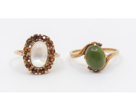 A moonstone and garnet set cluster 9ct gold ring, comprising an oval moonstone within a round mixed cut garnet surround, sett