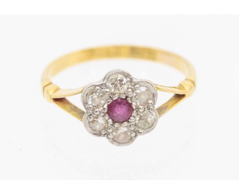 A ruby and diamond set 18ct gold cluster ring, comprising a central mixed cut ruby within a border of diamonds in a floral ar