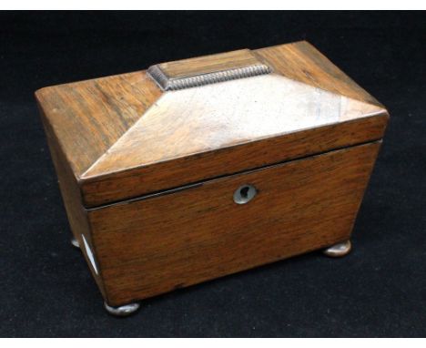 An early 20th century sarcophagus-shaped oak tea caddy on bun feet with zinc-lined twin compartments and a mother-of-pearl ke