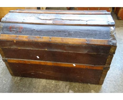 Late 19th early 20th century dome top canvas, metal and wooden banded traveling trunk with carrying handles and travelling la