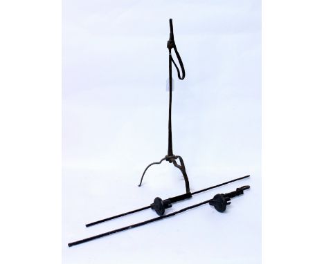 AN ANTIQUE IRON RUSH LIGHT HOLDER with a tripod base 58cm in height together with two antique iron adjustable candle holders 
