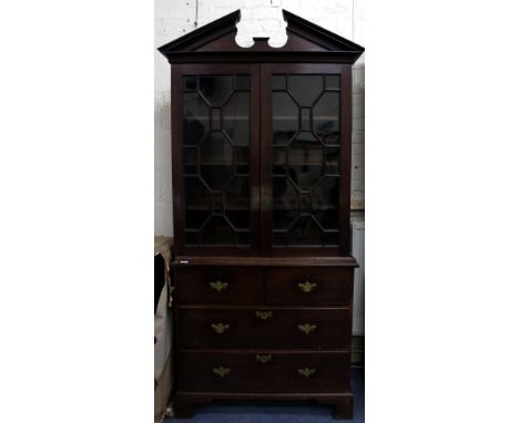 A GEORGE III MAHOGANY BOOKCASE ON CHEST with a break arch pediment, astral glazed doors above two short and two long drawers 