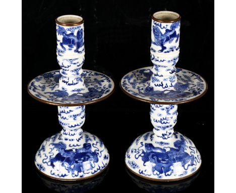 A pair of Chinese blue and white 'Dog of Fo' altar candlesticks, decorated in underglaze blue with dogs of fo and pups surrou