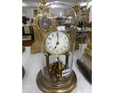 A Brass clock with enamel dial under glass dome.