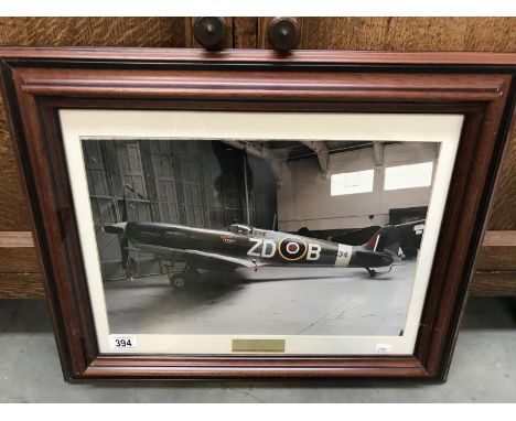 A framed and glazed print of a Spitfire signed by pilots Mark and Ray Hanna.