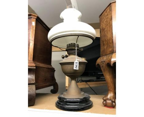 A brass oil lamp with mushroom shade.