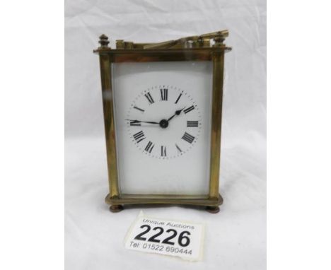 A brass carriage clock with key.