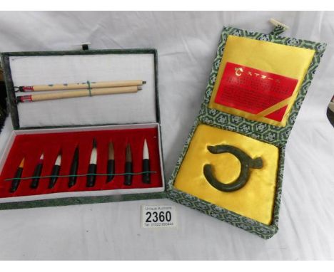 A jade 'The Dragon Jade' amulet and a Chinese calligraphy set.