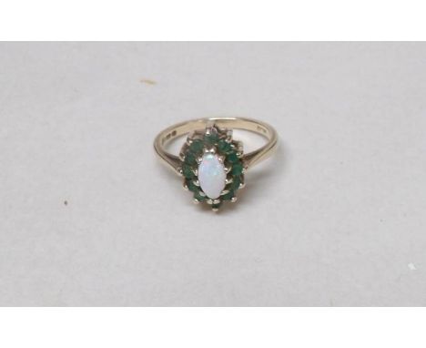 A 9ct gold ring set opal and emeralds, size M. Gross weight 2 grams.