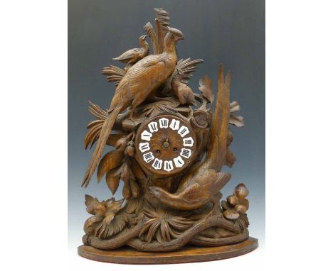 Black Forest mantel clock carved with pheasants amongst foliage, fitted with a French eight-day movement, height 57cm.