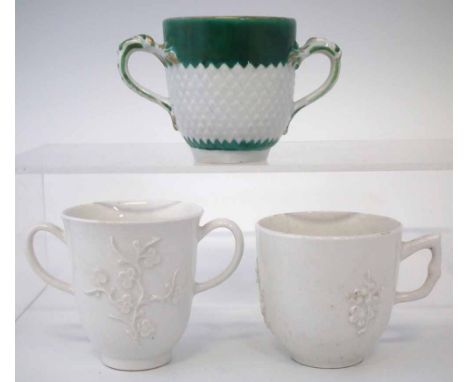 Two Bow chocolate cups and a coffee cup circa 1750 -1760, two left in blanc de chine moulded with prunus, the third painted w