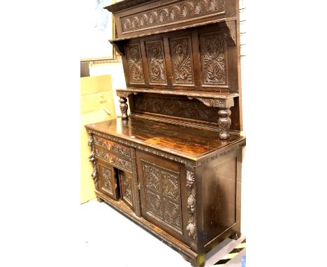 19thC Jacobean revival oak dresser, the heavily carved sideboard base of cupboards and drawers supports an open two shelf pla