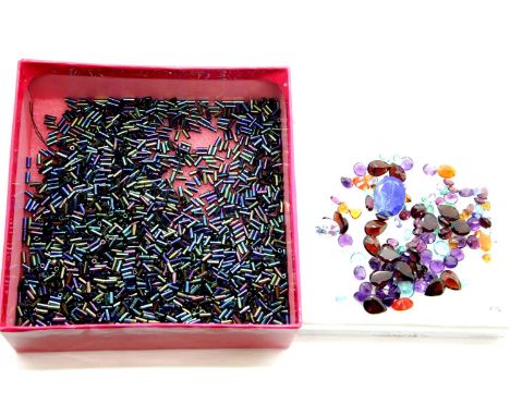 100 ct of mixed loose gemstones. Per label to include 3ct each of fire opal, tanzanite, aquamarine and emerald. P&amp;P Group