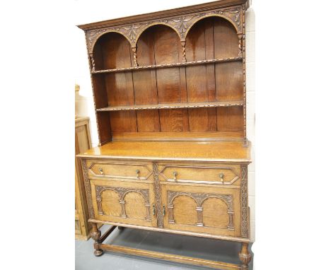 Late 19thC oak dresser, the sideboard base of cupboards and drawers supporting a two shelf plate rack, H: 201 cm. This lot is