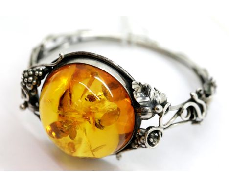 Sterling silver snap bangle set with a large Baltic amber type cabochon, 31g, D: 65 mm. P&amp;P Group 1 (£14+VAT for the firs