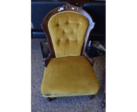 Late Victorian button upholstered nursing chair with yellow upholstery and carved frame