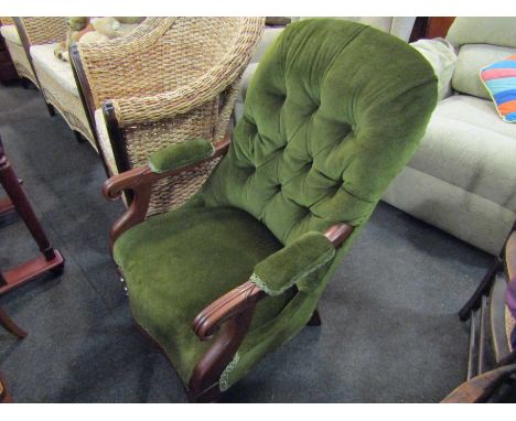 A Regency walnut button back armchair, the carved scroll end arms over turned legs and brass castors   