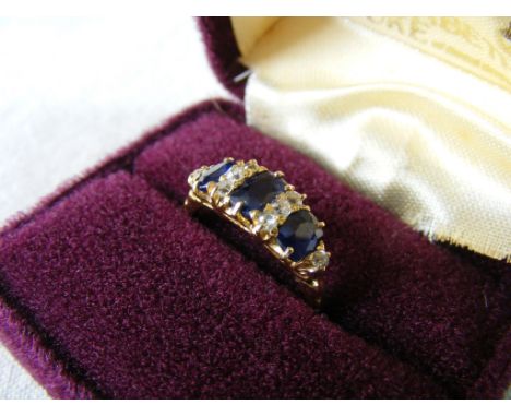 A high-carat yellow-metal Ring, set with blue  stones interspaced with small Diamonds.