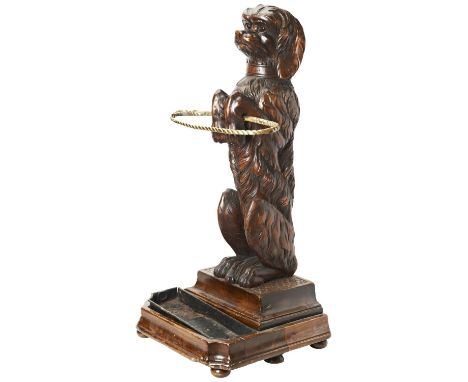 A GOOD 19TH CENTURY BLACK FOREST BRASS-MOUNTED LINDEN WOOD STICK STAND in the form of a begging dog with glass inset eyes, th