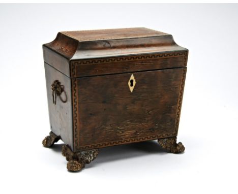 A GEORGE III WALNUT TEA CADDY  of tapering sarcophagus form with key pattern borders, brass handles and feet and two compartm