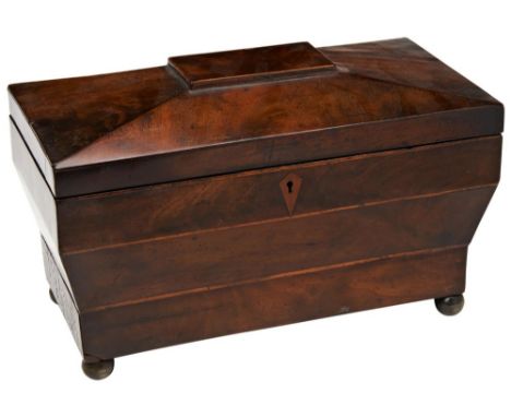 A GEORGE III SARCOPHAGUS FORM MAHOGANY TEA CADDY the interior with glass mixing bowl, two lidded compartments, the base with 