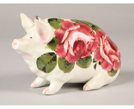 Wemyss ware pig, hand painted with cabbage rose decoration, 16cm long. The pig is heavily crazed throughout , both ears are c