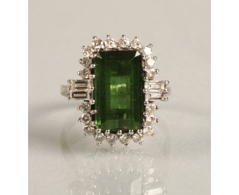 Ladies 18ct white gold emerald and diamond ring, central emerald surrounded by twenty small brilliant cut diamonds, with two 