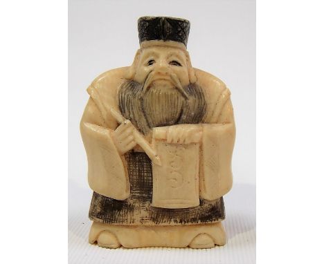 Japanese Meiji period carved ivory Netsuke carved in the form of an elderly calligrapher holding brush and scroll, signed to 