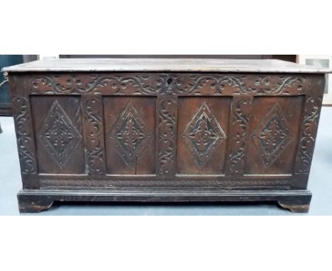 18th Century oak coffer, the four panel front with four foliate carved lozenge flanked with foliate scrolls upon bracket feet