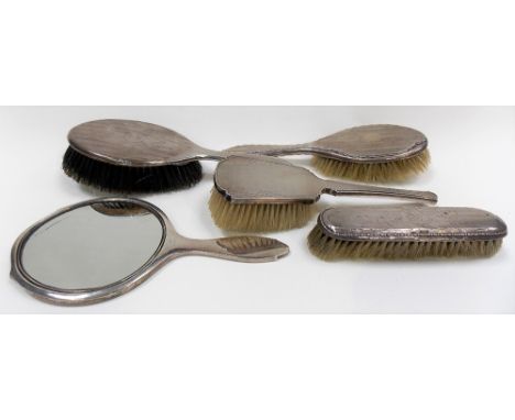 Five silver engine turned dressing table items including a hand mirror.
