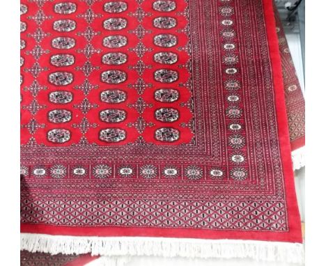 Large modern Turkoman carpet with six rows of medallions within multiple borders and on a red ground