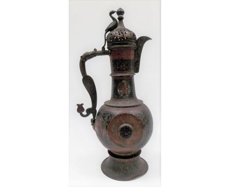An Indo-Persian copper and enamel coffee pot of baluster pedestal form, the pierced dome lid with bird applied finial, the ha