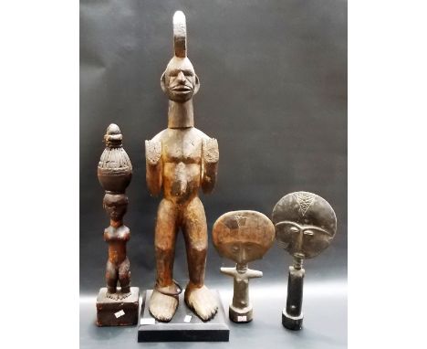 Two African standing tribal figures, the largest with an iron ring on his right foot; together with two African tribal dolls,
