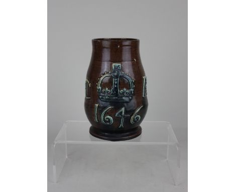 An Edward Bingham Castle Hedingham brown glazed pottery mug commemorating Charles II, decorated in raised relief with a crown