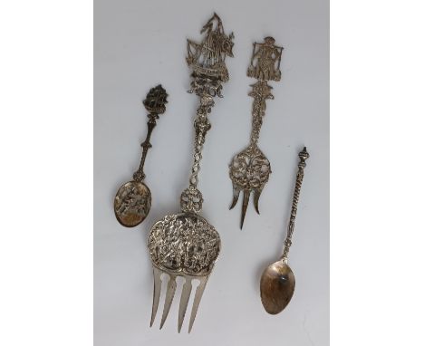 A Dutch silver serving fork with sailing ship terminal 22cm, a smaller fork with milkmaid terminal and two metal spoons 