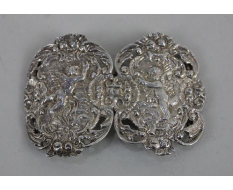 A Victorian nurses silver belt buckle in two pierced oval sections embossed with cherubs and fruit, maker Loewe Rosenthal, Lo