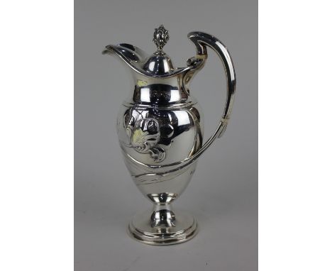 A late Victorian Art Nouveau silver claret jug baluster form with hinged lid and bud finial handle, embossed floral decoratio