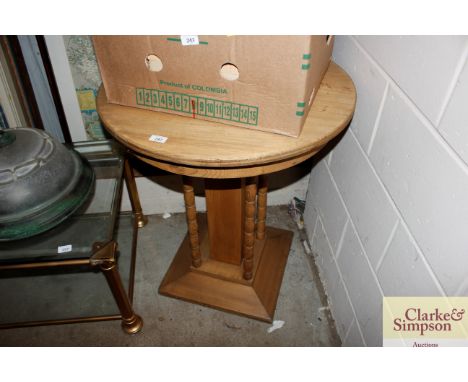 A circular pine pedestal table raised on bobbin supports