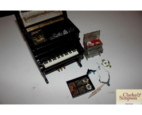 A musical trinket box in the form of a piano and another with contents of badges