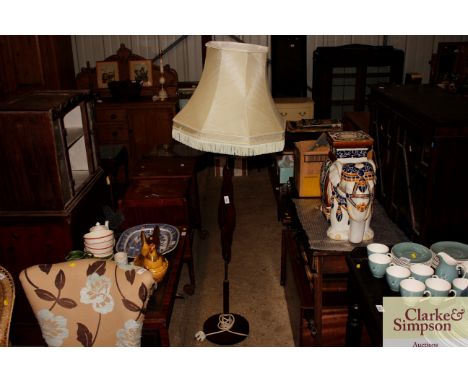 A teak standard lamp and shade