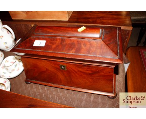An early 19th Century mahogany sarcophagus shaped tea caddy with twin compartments and mixing bowl