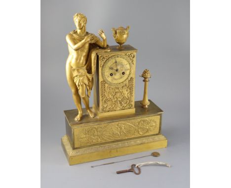 A 19th century French Empire style ormolu mantel clock, modelled with a classical musician standing beside an urn, the case d