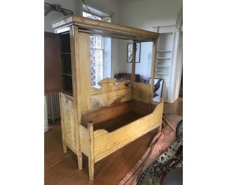A 19th Swedish grained pine extending box bed, combined cupboard, with moulded cornice and front rail, architectural shaped b