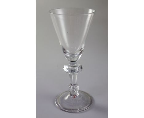 An English or Dutch light baluster wine glass, c.1740, the funnel shaped bowl above a teardrop inverted baluster stem, on a f