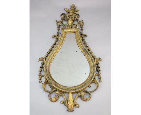 An early 19th century giltwood and gesso wall mirror, tear drop shaped with urn, flower and bell husk crest over a foliate bo